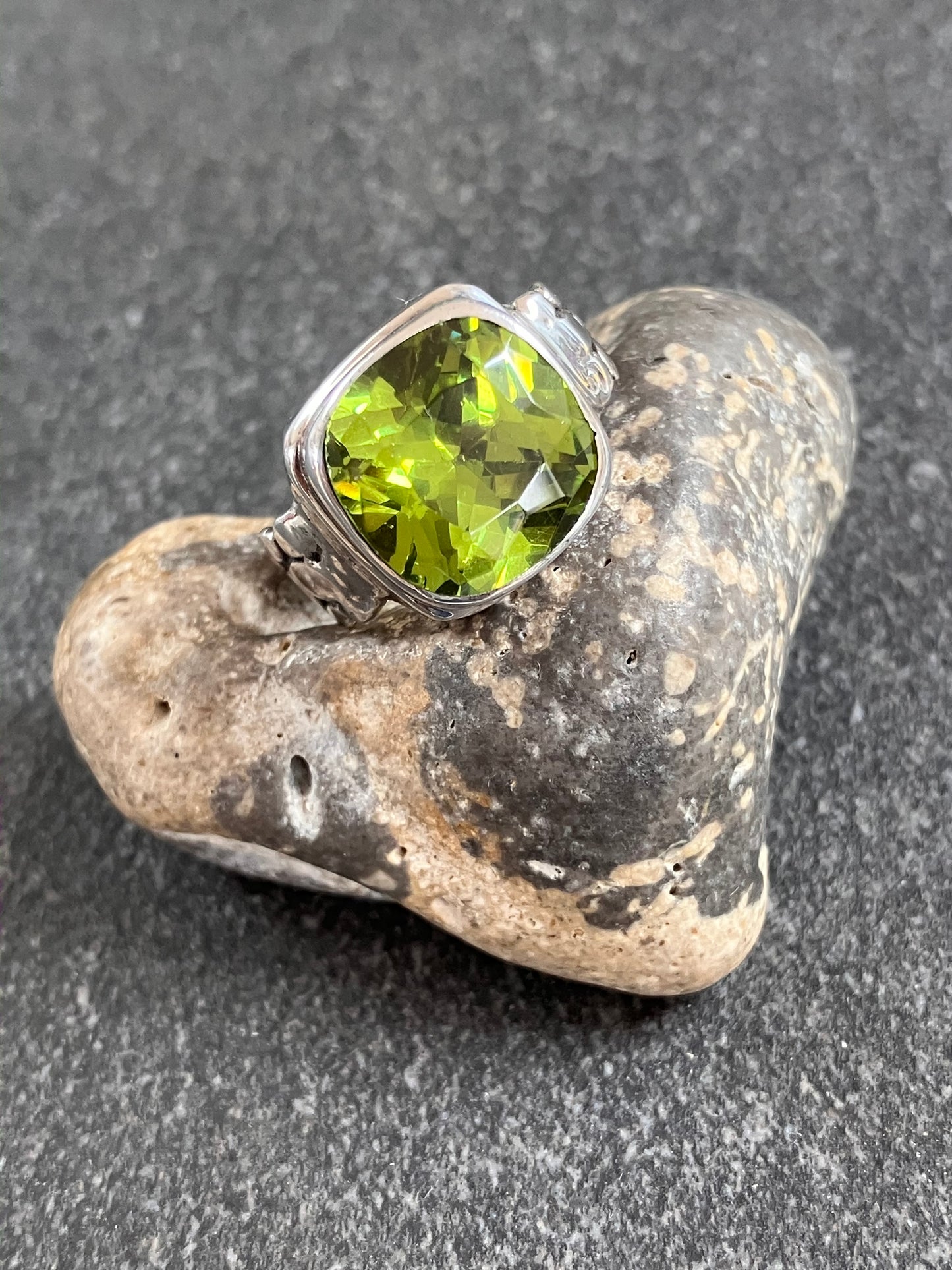 This striking vintage ring features a brilliantly vibrant piece of green chamfered cut glass.
