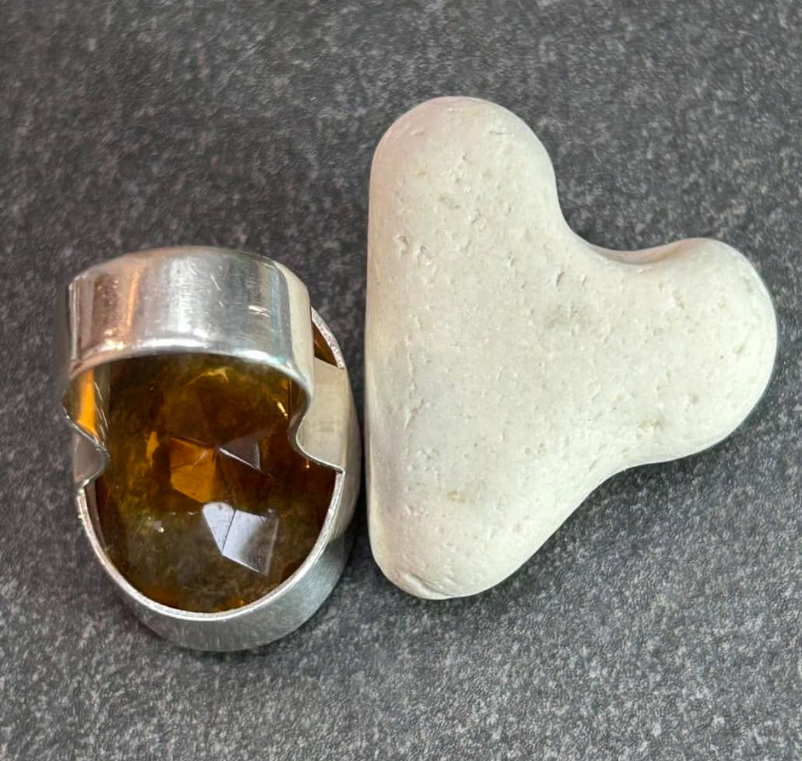 This absolutely stunning vintage cocktail ring features a beautifully cut piece of rich amber glass