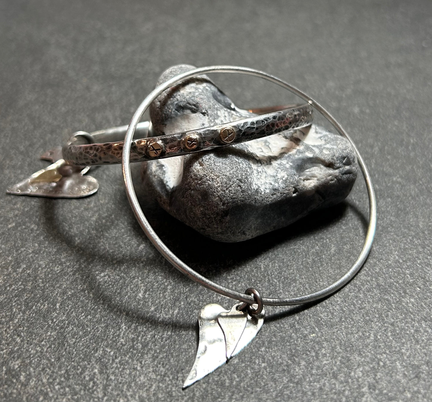 Delicate artisan bangle with two silver hearts.