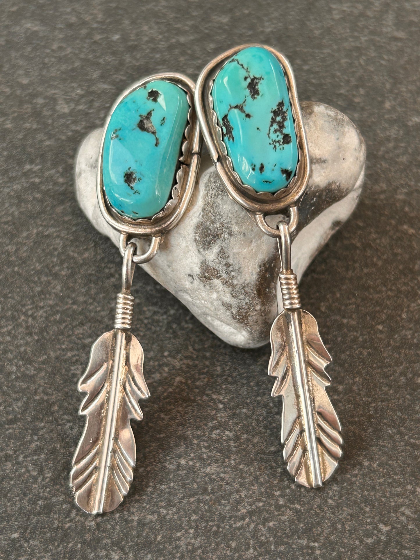Beautiful vintage Native American sterling silver earrings featuring striking turquoise cabochons and feathers.
