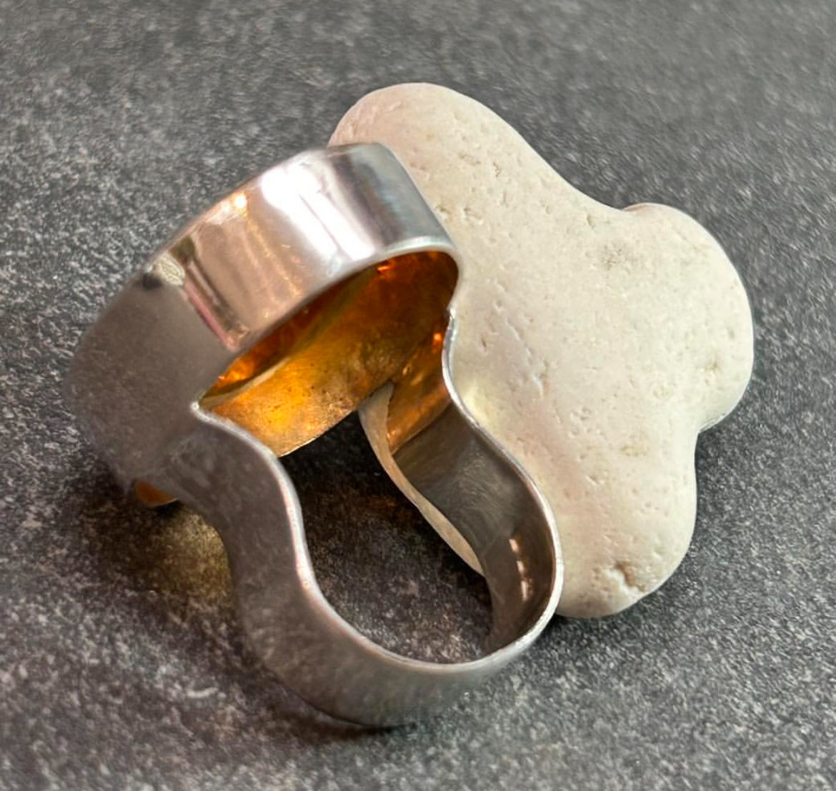 This absolutely stunning vintage cocktail ring features a beautifully cut piece of rich amber glass
