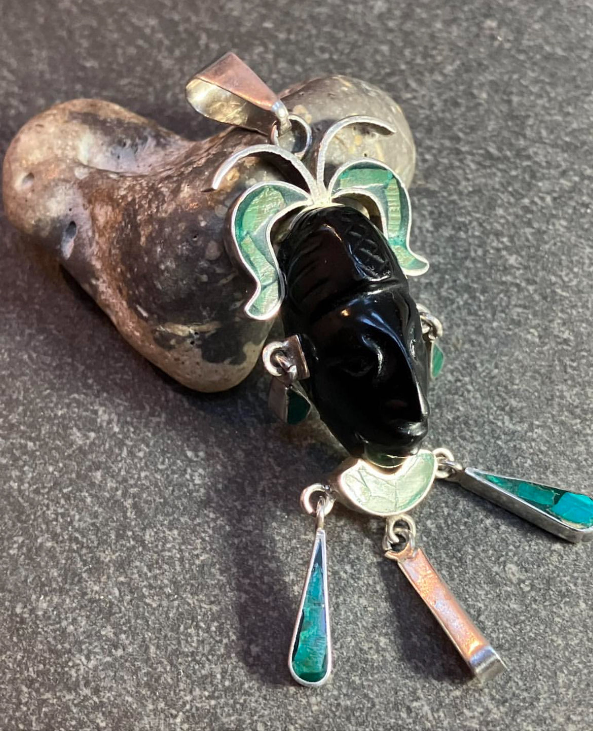 A striking vintage Mexican warrior face pendant crafted in sterling silver.