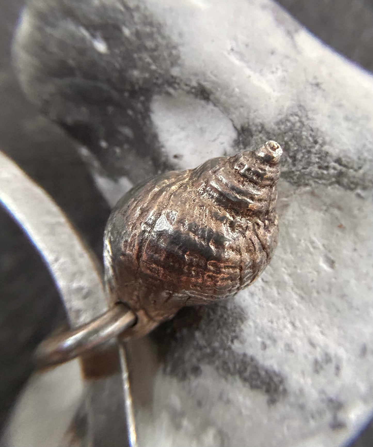 Delicate artisan sterling silver bangle with shell charm.
