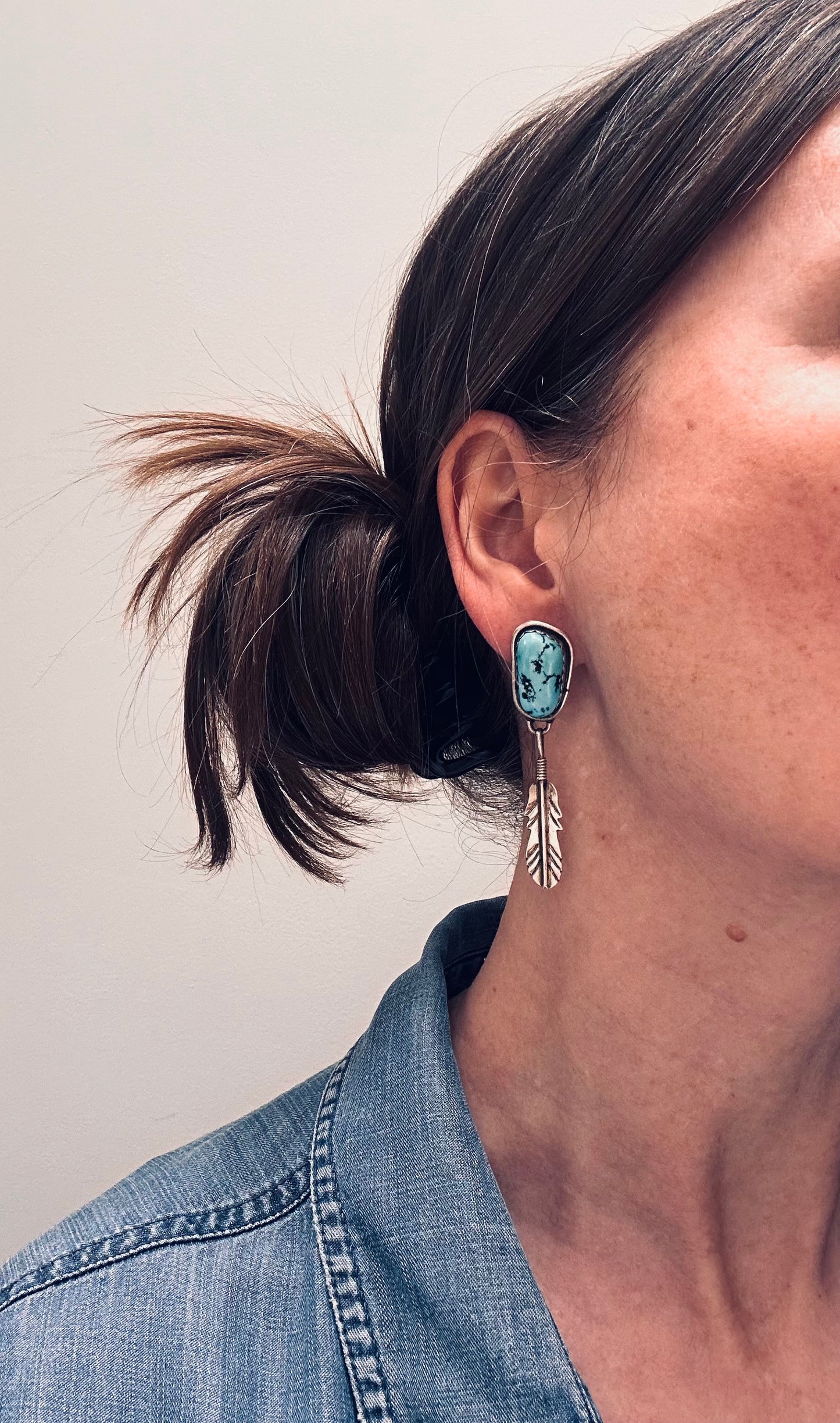Beautiful vintage Native American sterling silver earrings featuring striking turquoise cabochons and feathers.