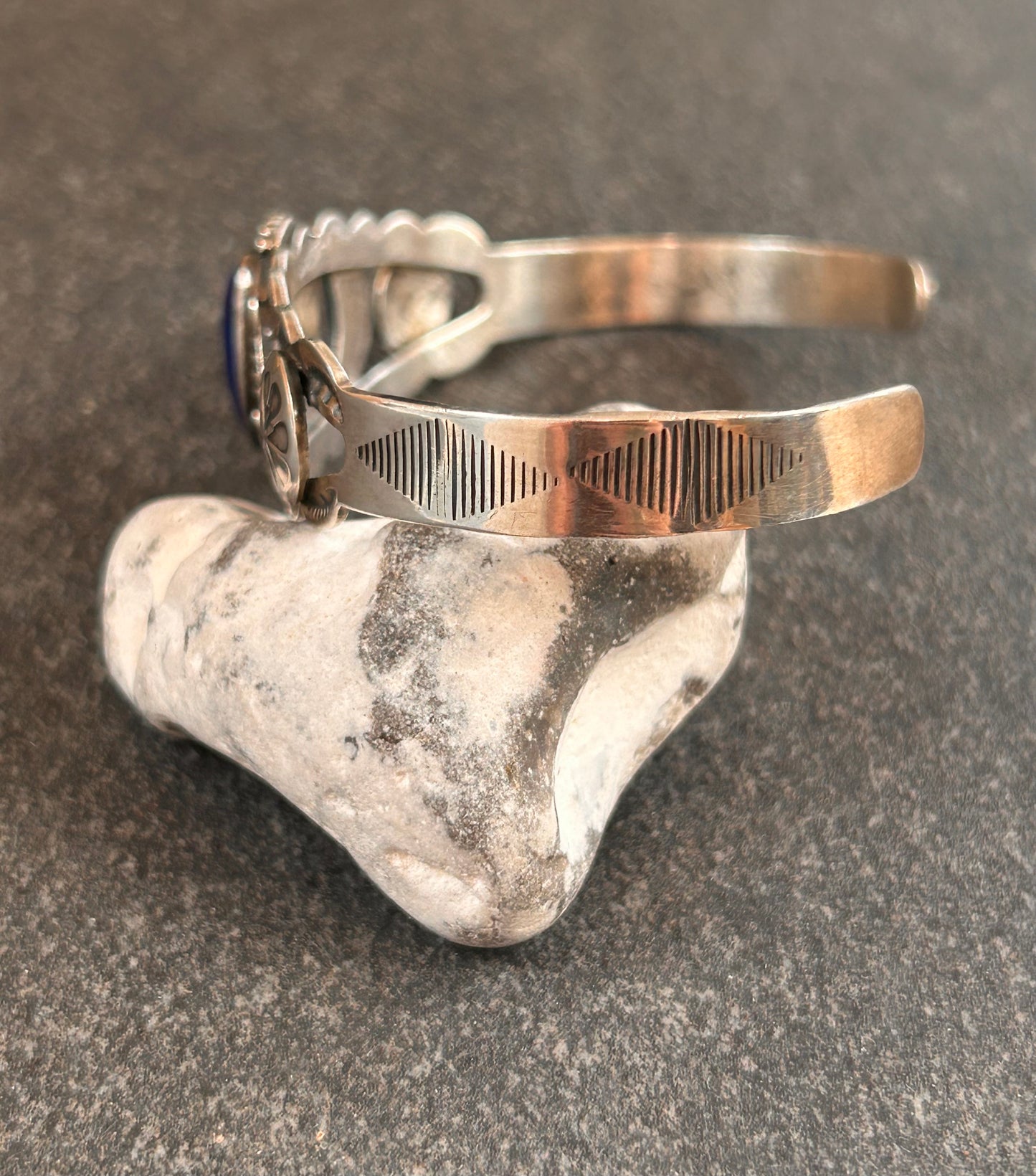 Vintage sterling silver Native American bangle featuring a striking central cabochon of lapis lazuli