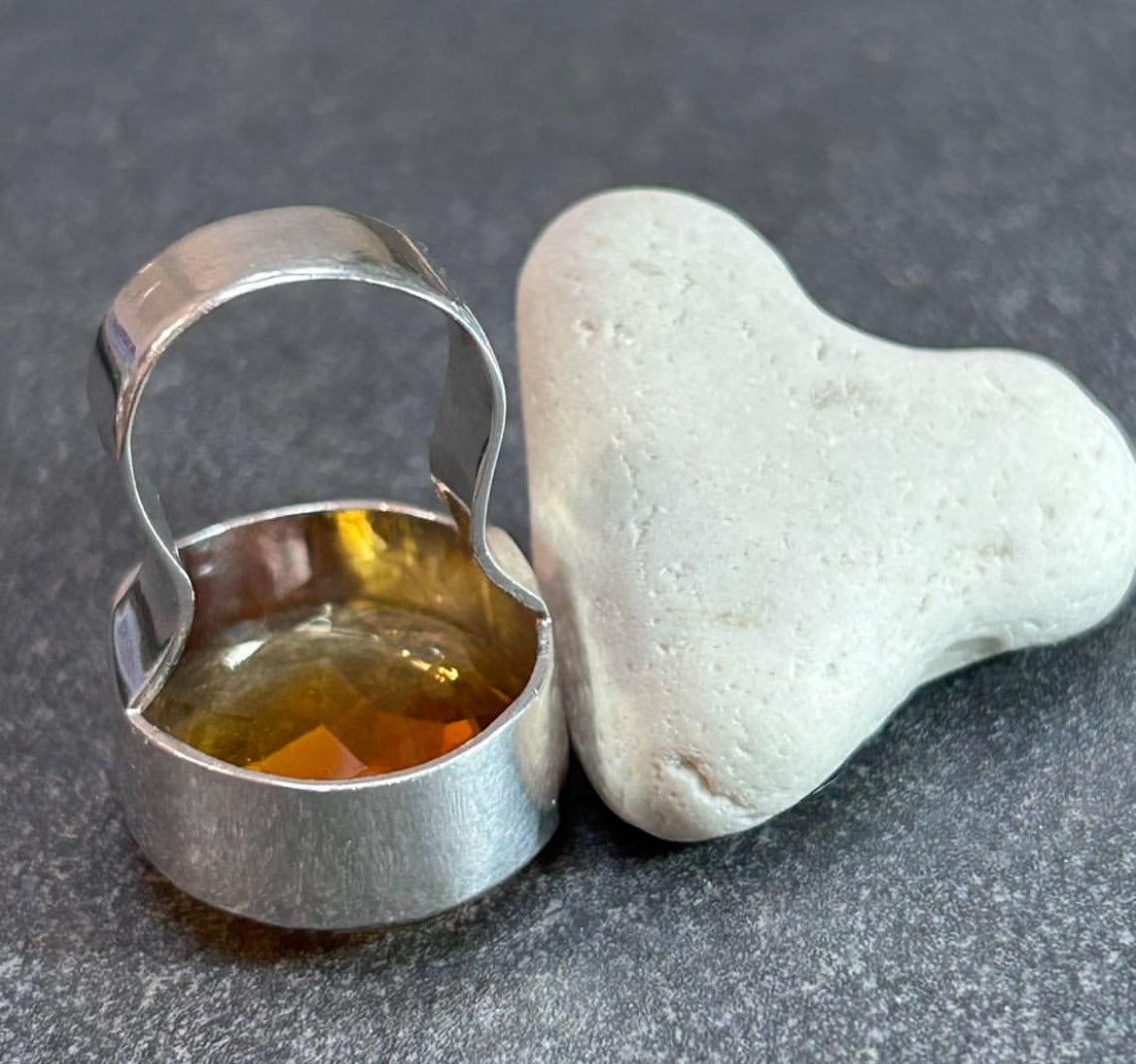 This absolutely stunning vintage cocktail ring features a beautifully cut piece of rich amber glass