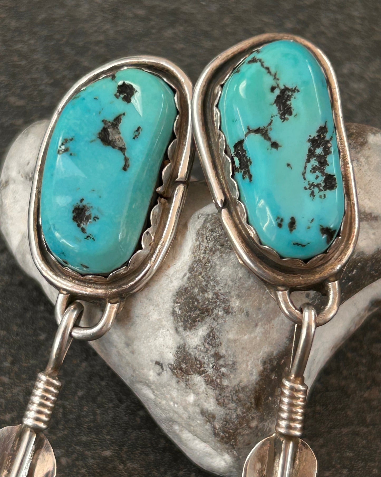 Beautiful vintage Native American sterling silver earrings featuring striking turquoise cabochons and feathers.