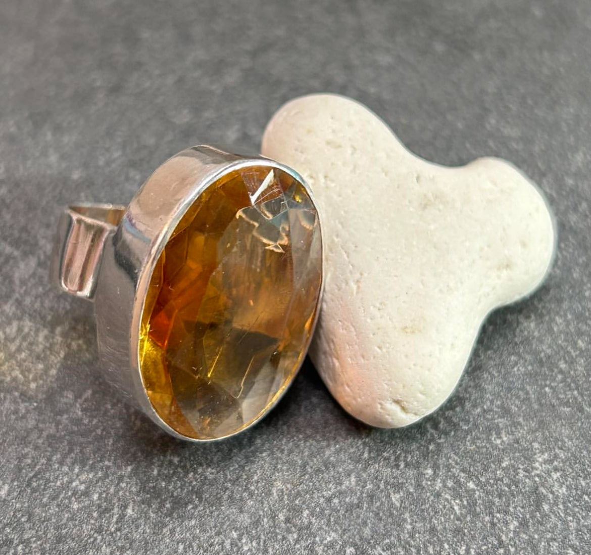 This absolutely stunning vintage cocktail ring features a beautifully cut piece of rich amber glass