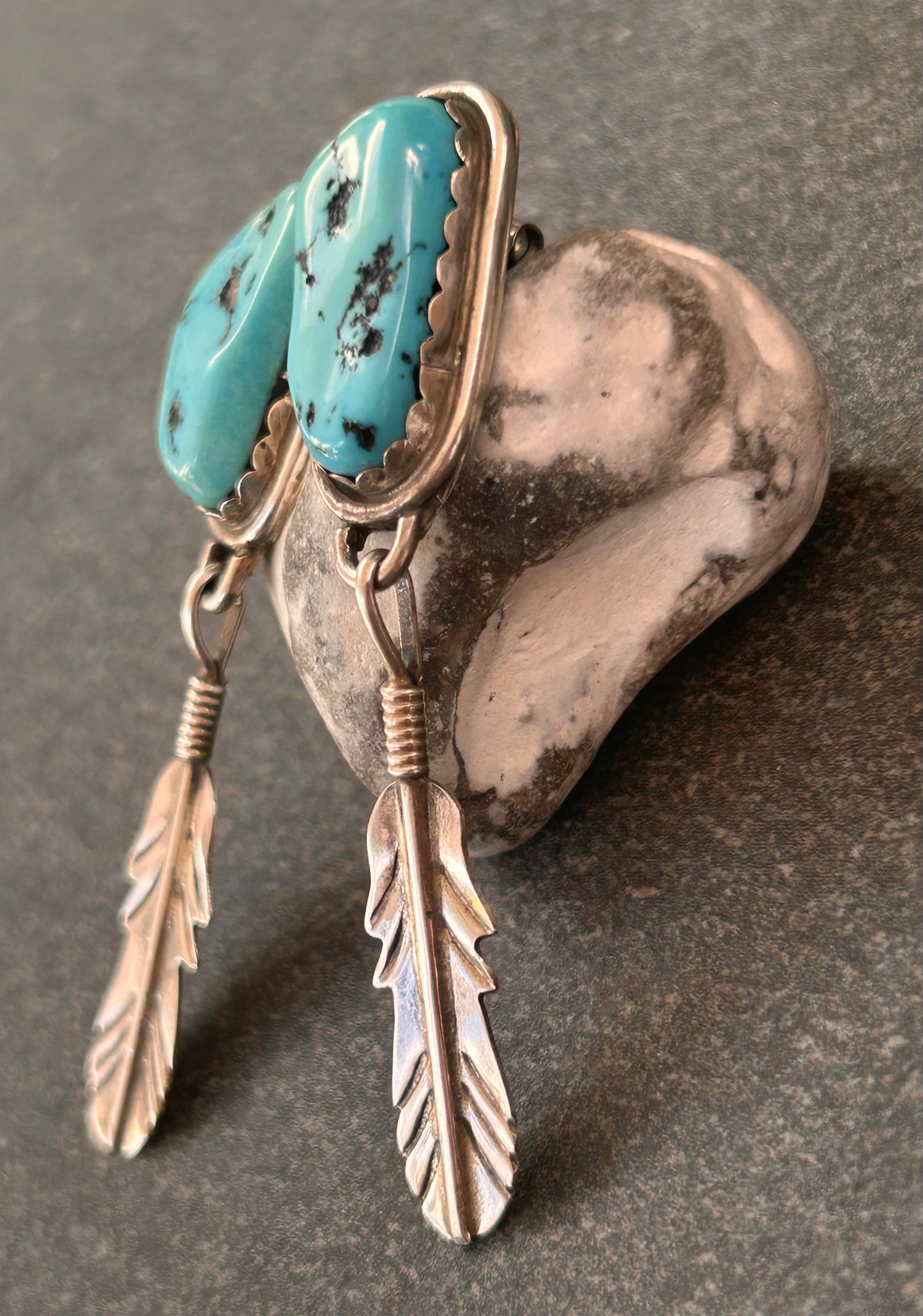 Beautiful vintage Native American sterling silver earrings featuring striking turquoise cabochons and feathers.