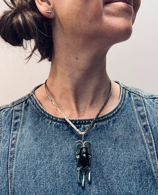 A striking vintage Mexican warrior face pendant crafted in sterling silver.