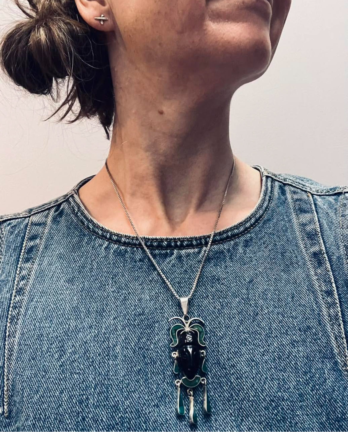 A striking vintage Mexican warrior face pendant crafted in sterling silver.