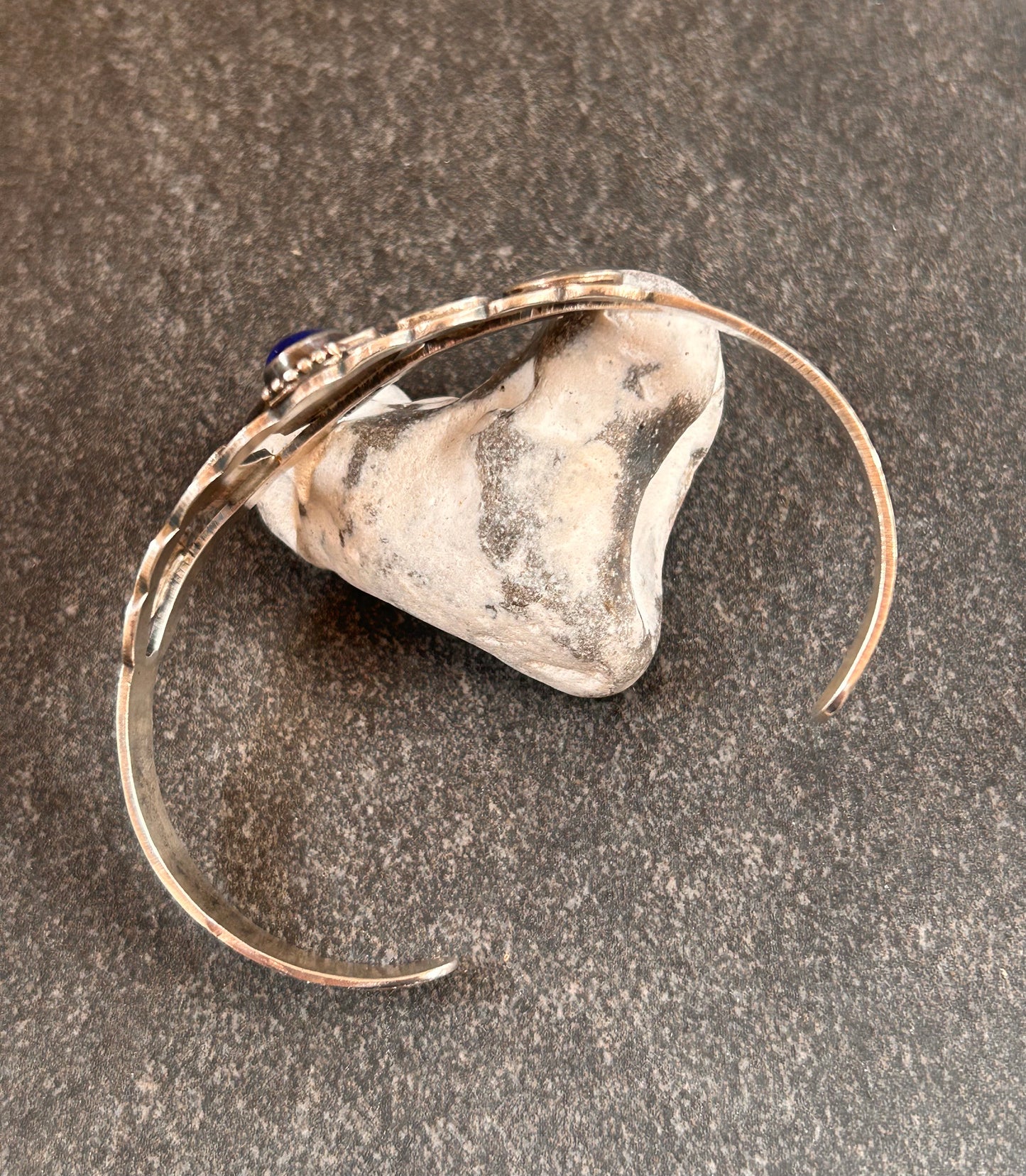 Vintage sterling silver Native American bangle featuring a striking central cabochon of lapis lazuli