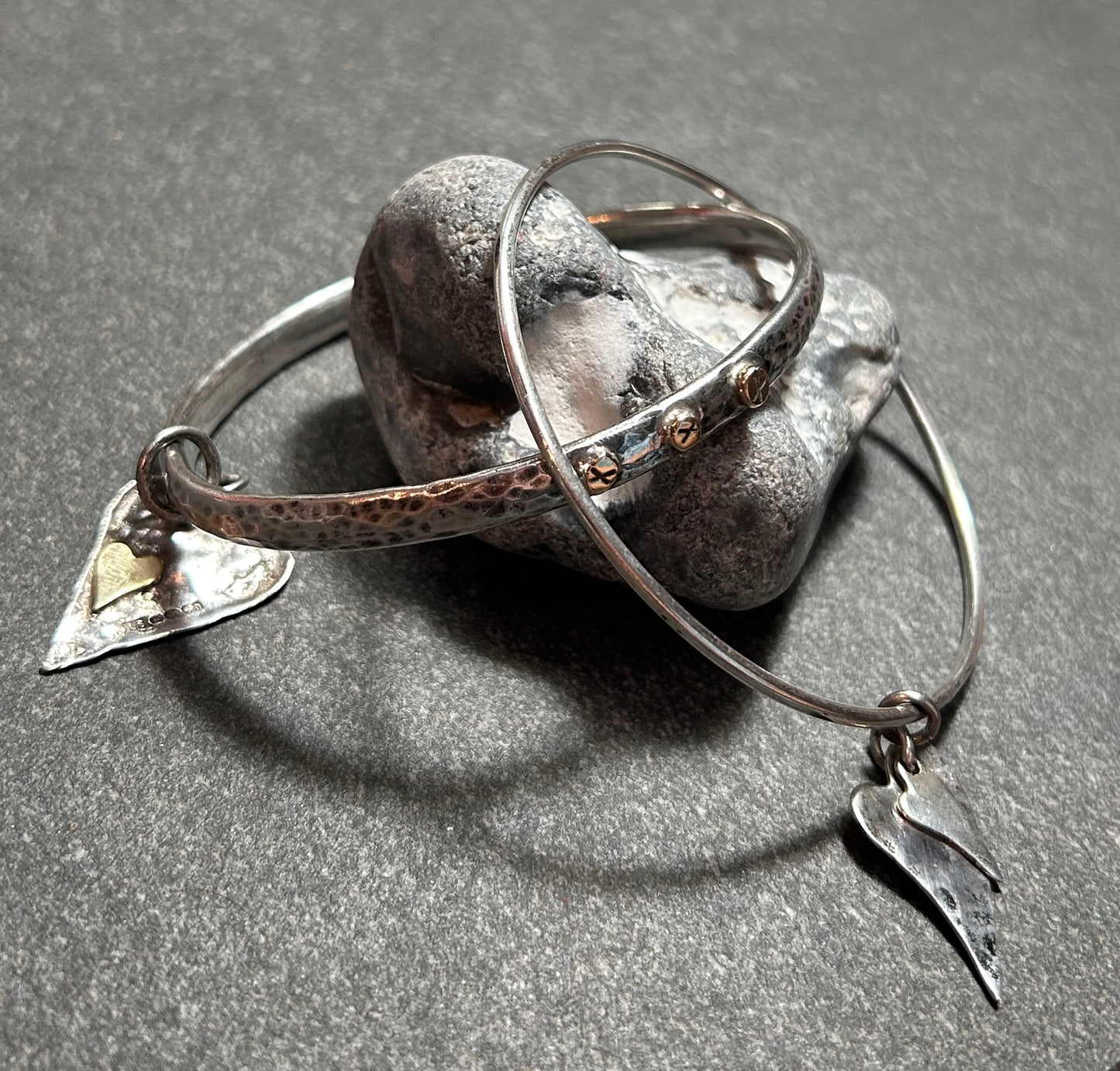 Delicate artisan bangle with two silver hearts.