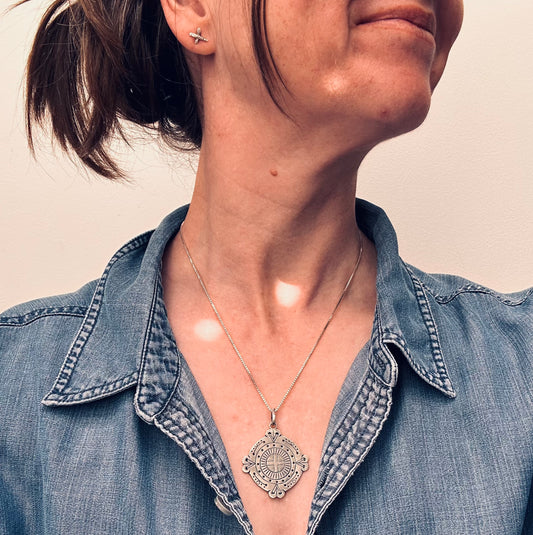 A captivating vintage sterling silver bohemian pendant featuring the ancient sun cross