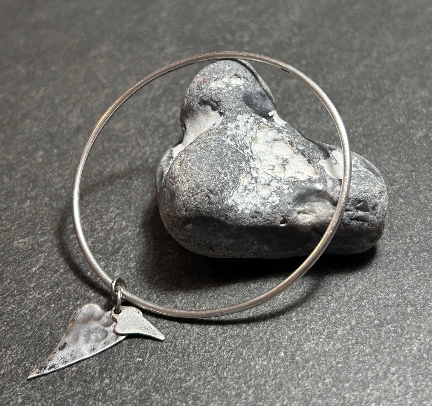 Delicate artisan bangle with two silver hearts.