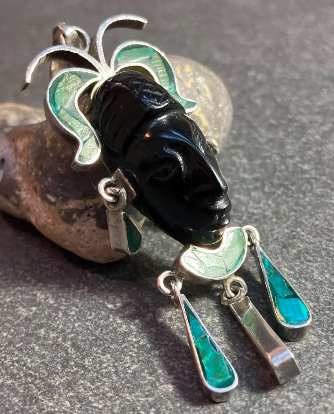 A striking vintage Mexican warrior face pendant crafted in sterling silver.