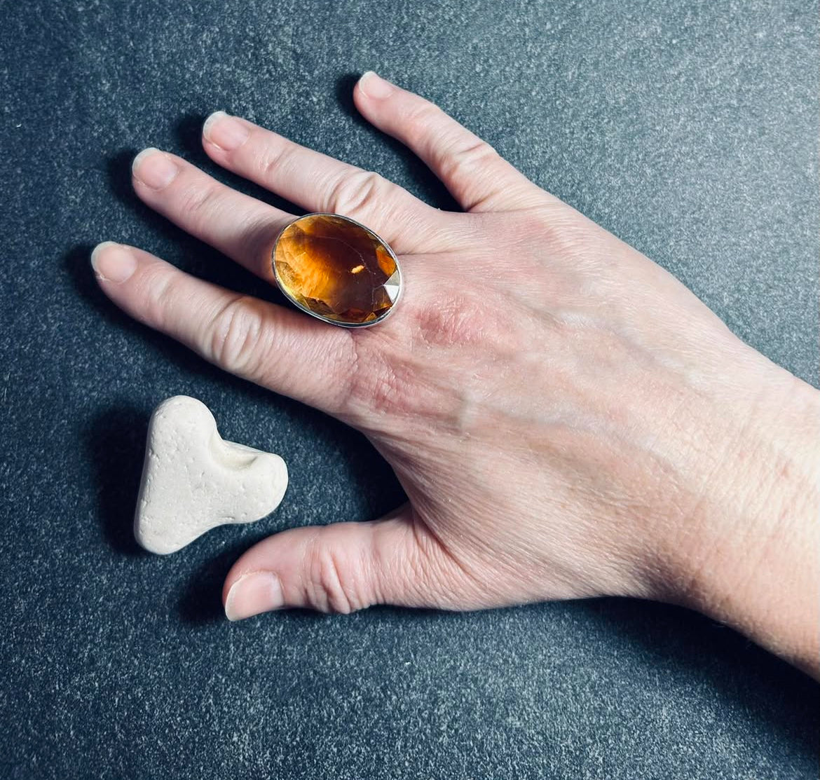 This absolutely stunning vintage cocktail ring features a beautifully cut piece of rich amber glass