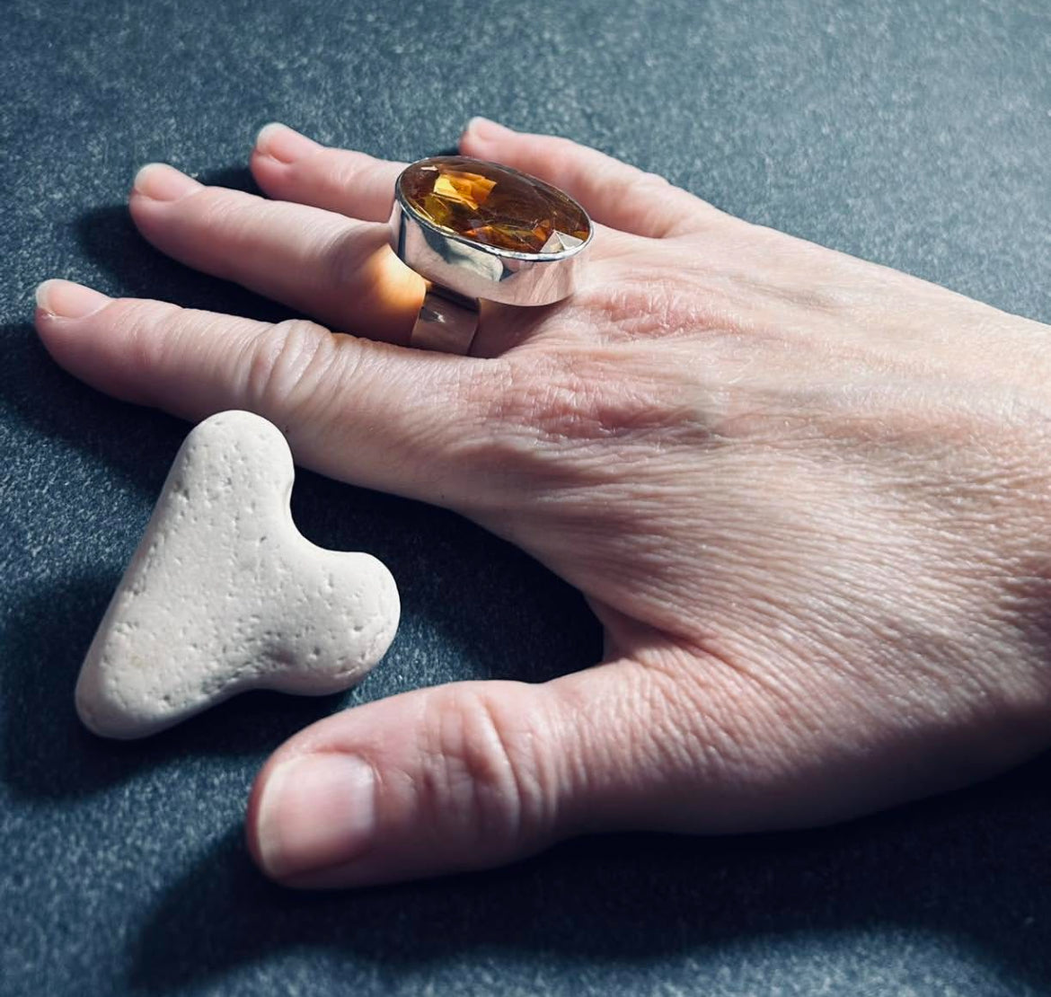 This absolutely stunning vintage cocktail ring features a beautifully cut piece of rich amber glass