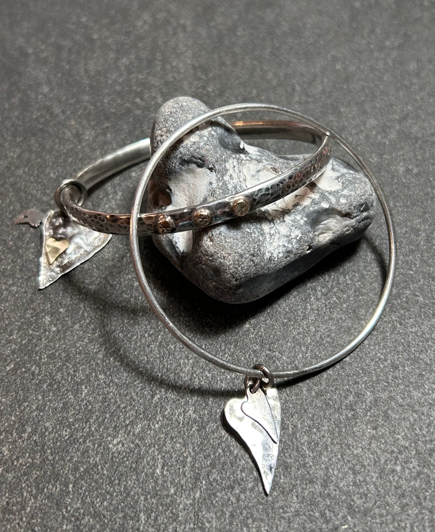 Delicate artisan bangle with two silver hearts.