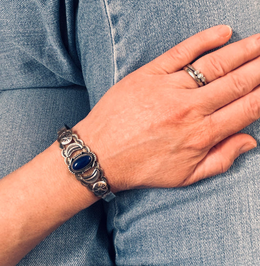 Vintage sterling silver Native American bangle featuring a striking central cabochon of lapis lazuli