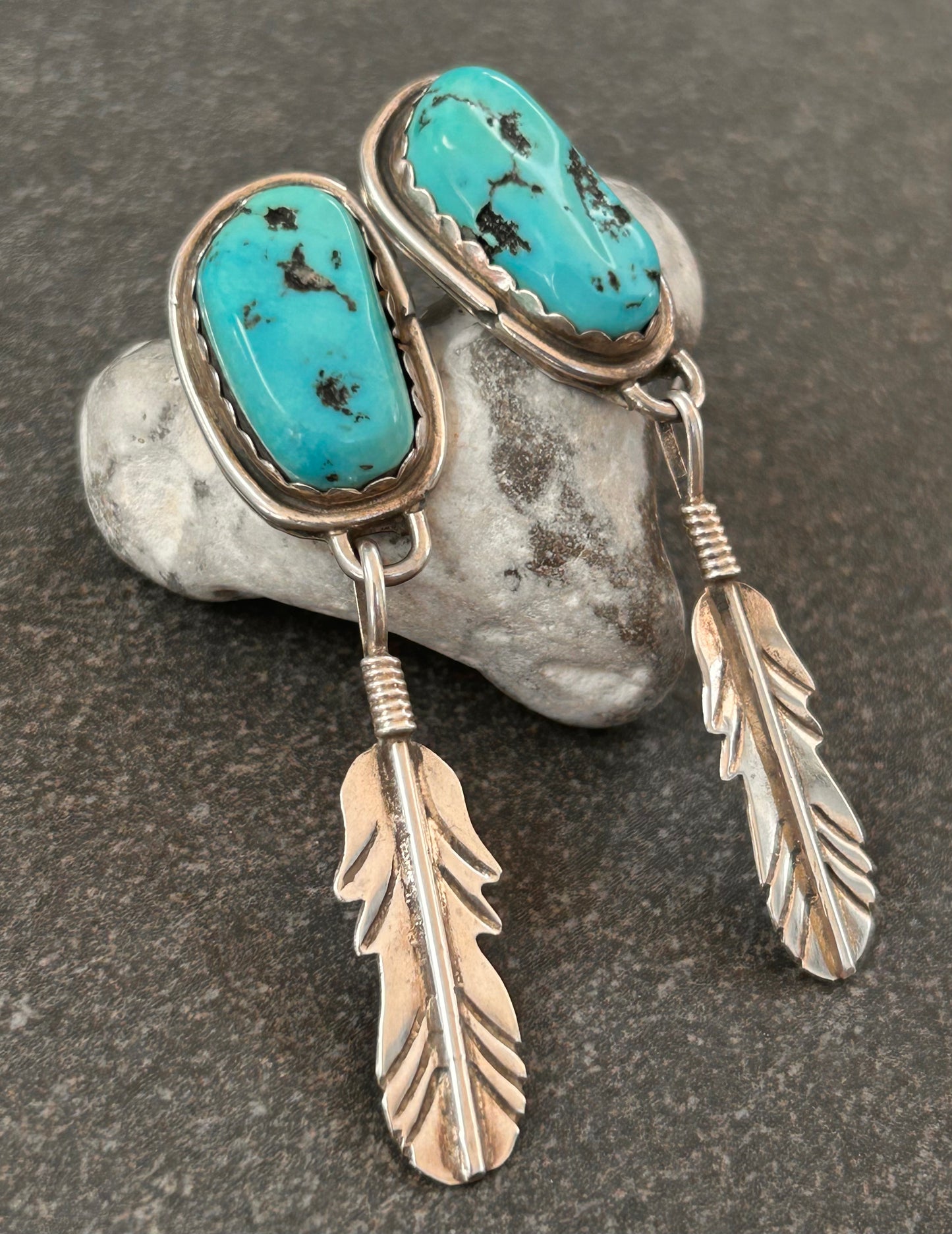 Beautiful vintage Native American sterling silver earrings featuring striking turquoise cabochons and feathers.