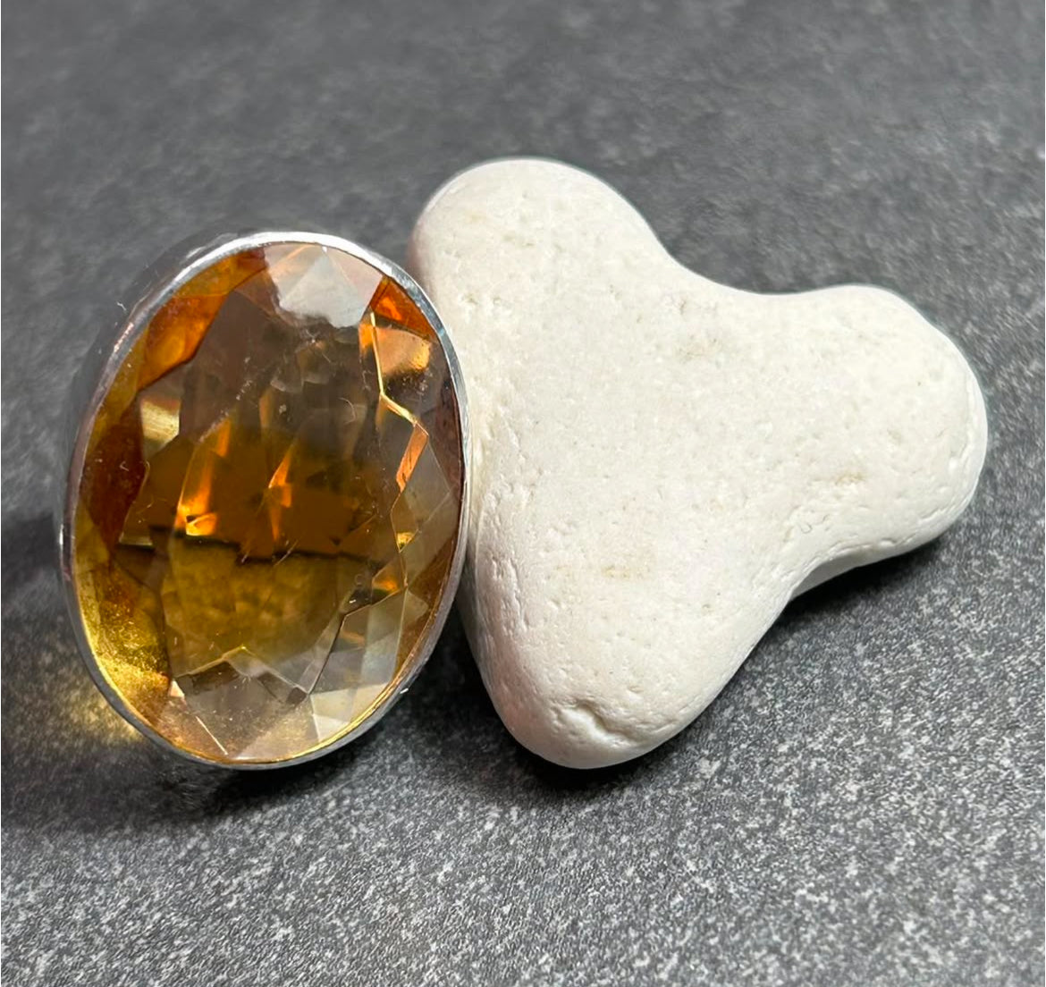 This absolutely stunning vintage cocktail ring features a beautifully cut piece of rich amber glass