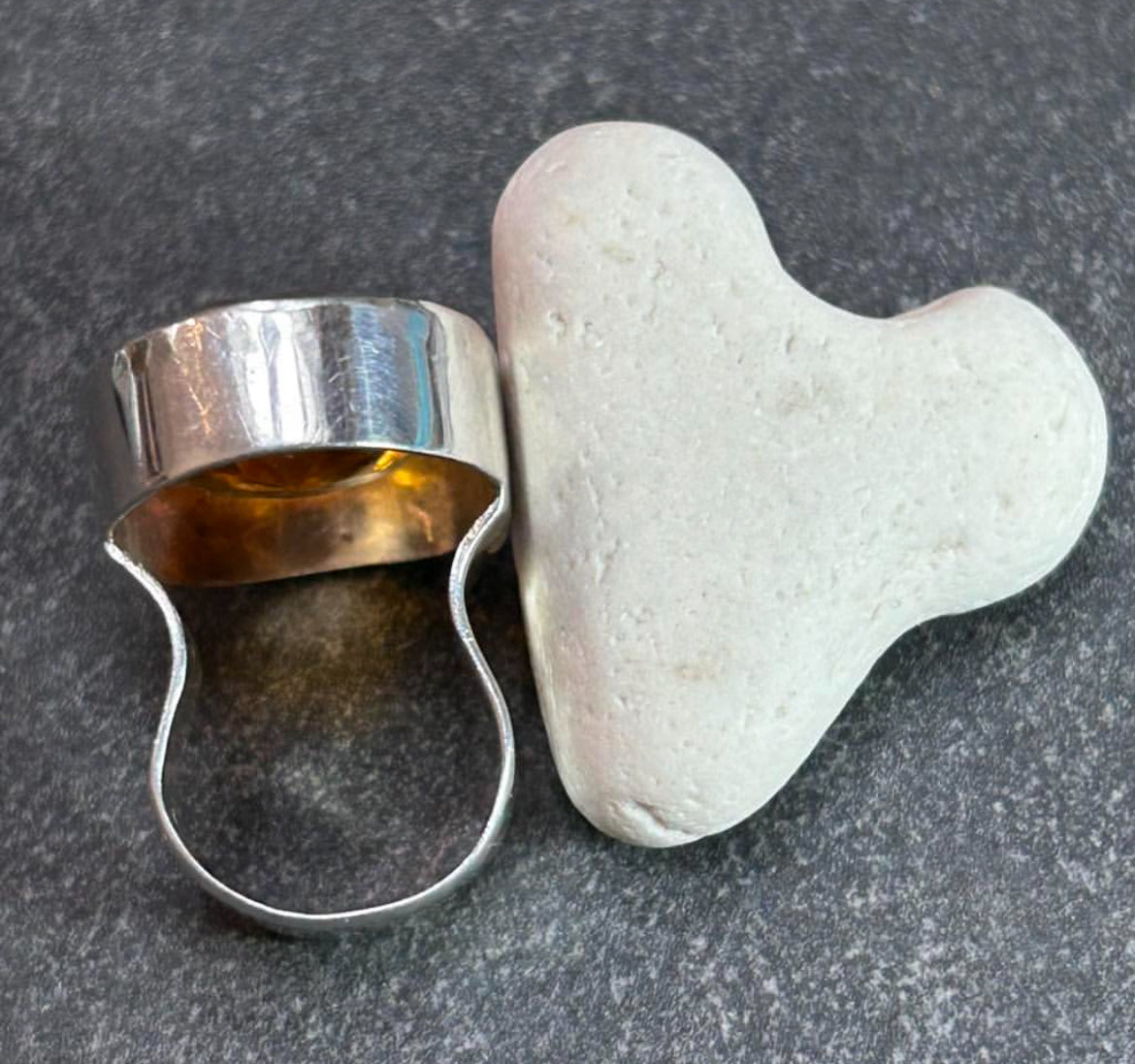 This absolutely stunning vintage cocktail ring features a beautifully cut piece of rich amber glass