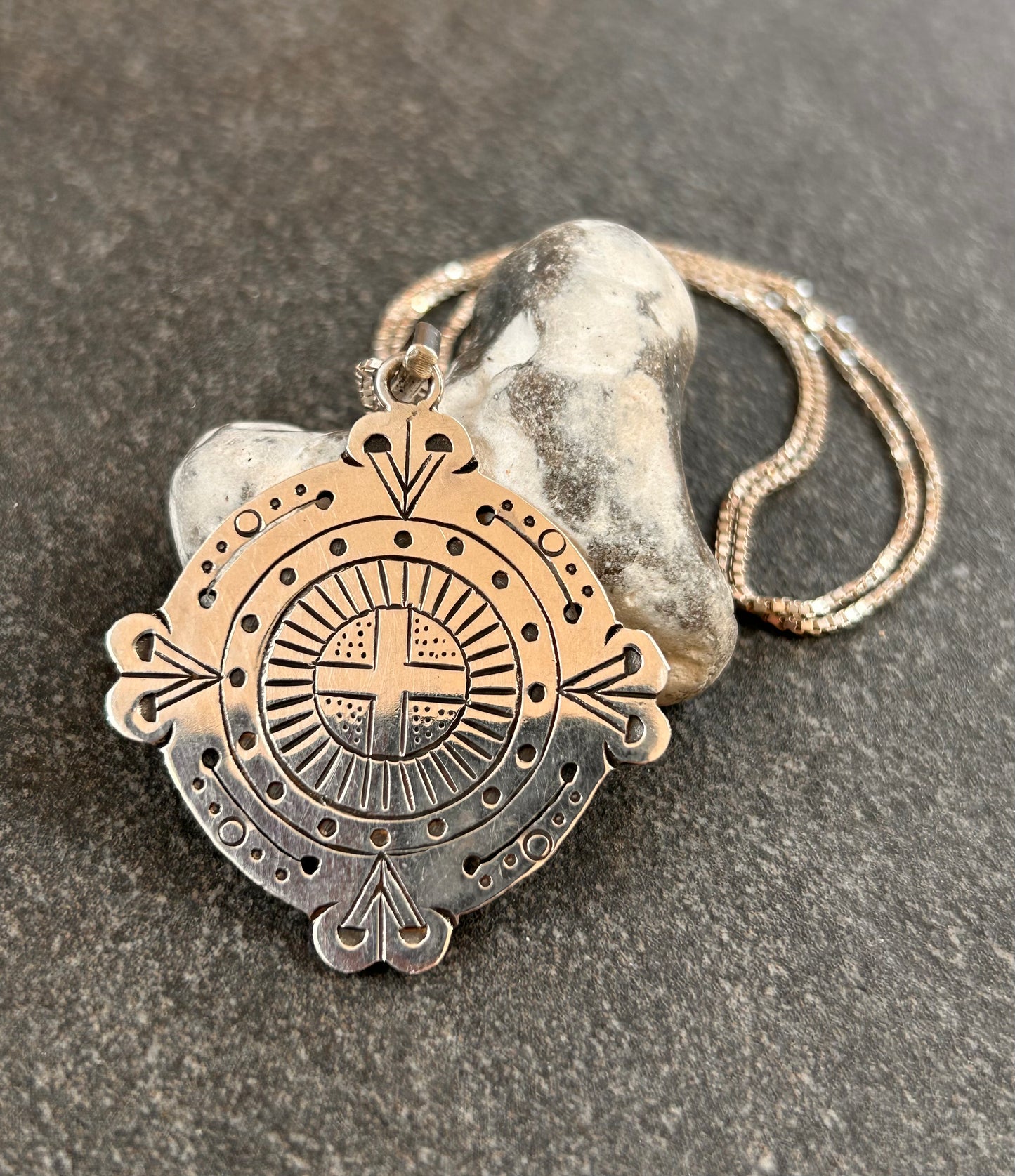 A captivating vintage sterling silver bohemian pendant featuring the ancient sun cross