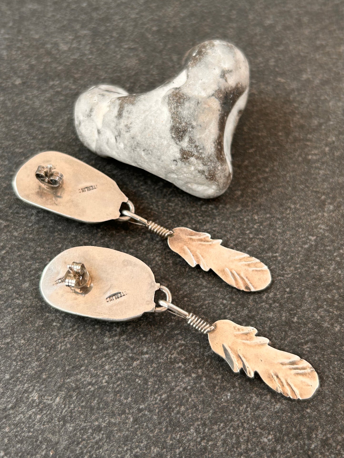 Beautiful vintage Native American sterling silver earrings featuring striking turquoise cabochons and feathers.