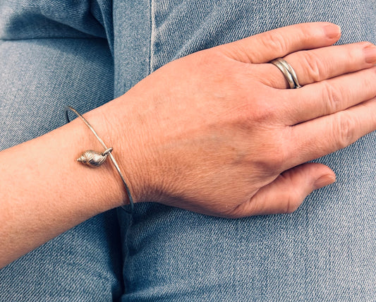 Delicate artisan sterling silver bangle with shell charm.