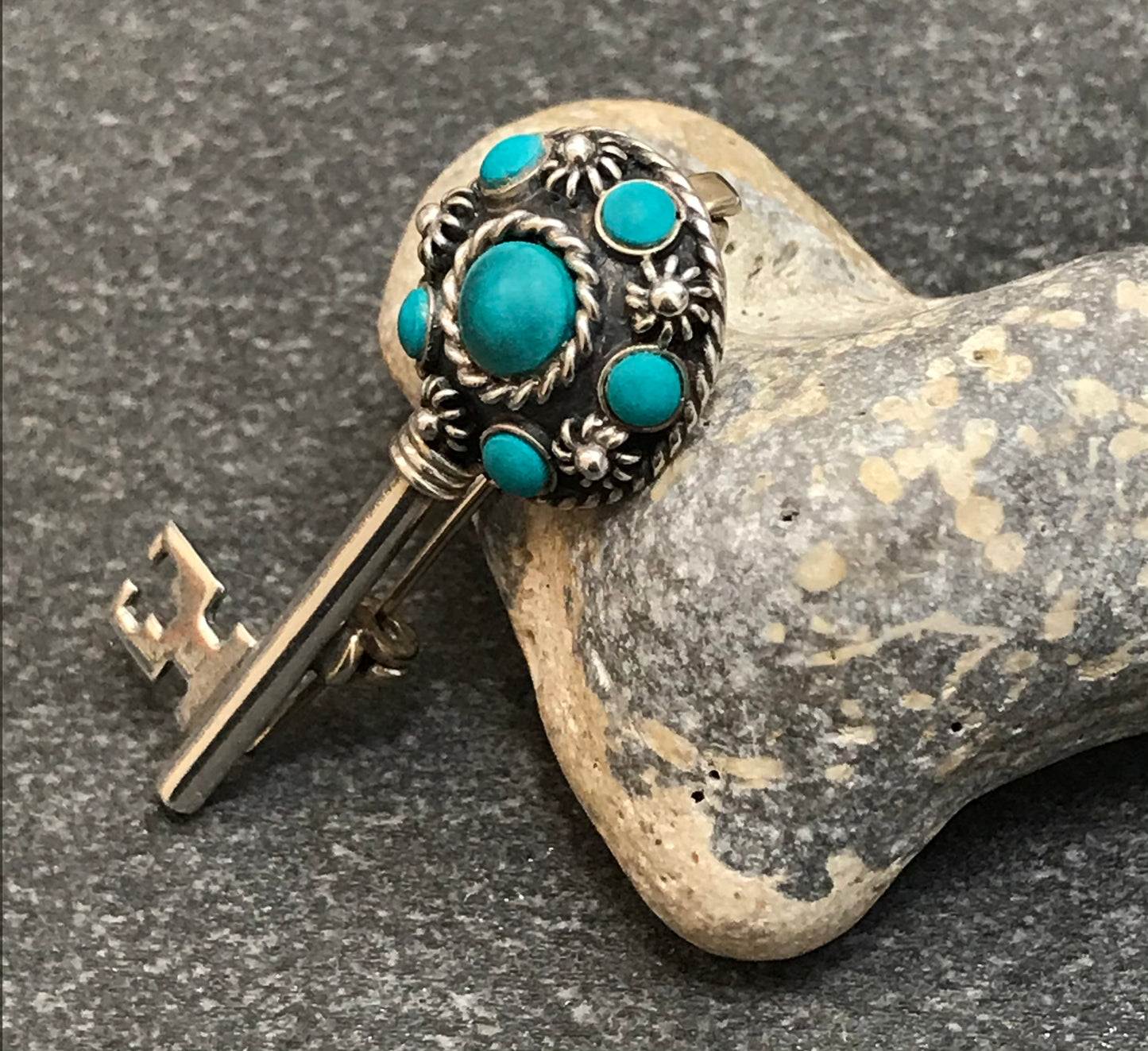 Vintage sterling silver key brooch with lovely turquoise cabochons.