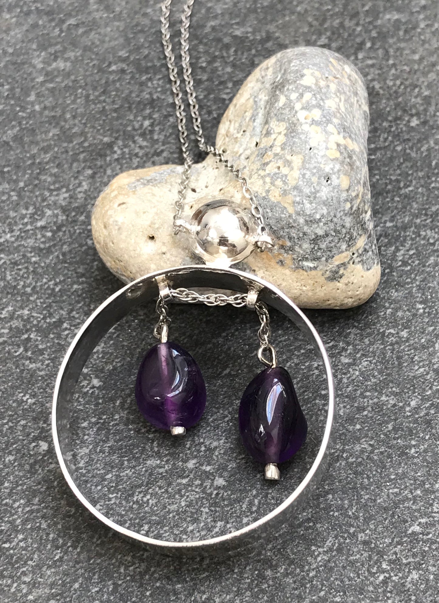 Unusual vintage circular sterling silver pendant with two amethyst drops suspended on a moving sterling silver chain.