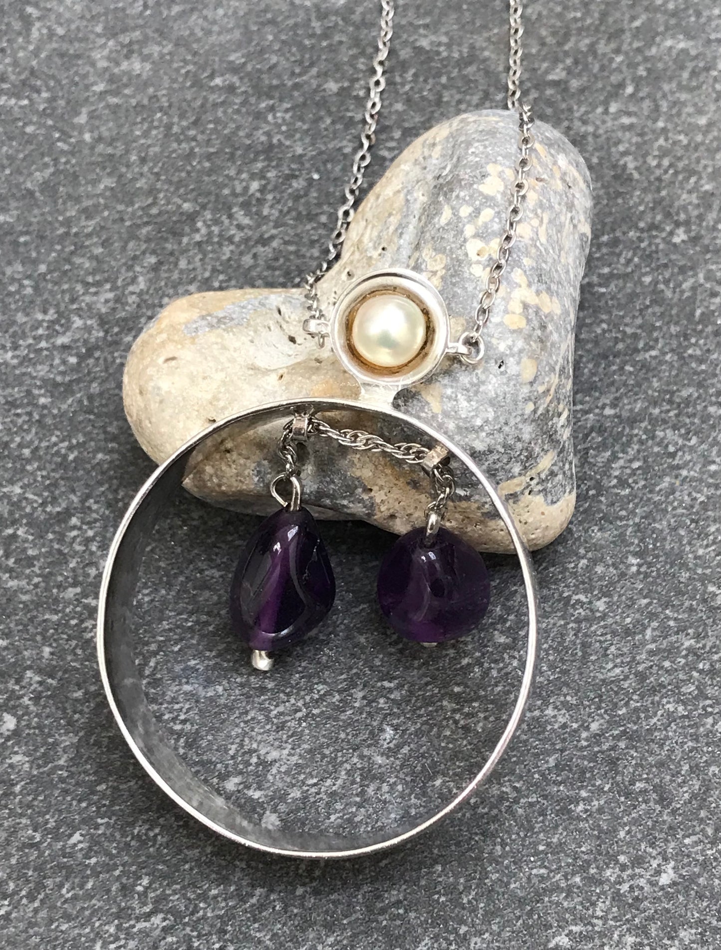 Unusual vintage circular sterling silver pendant with two amethyst drops suspended on a moving sterling silver chain.