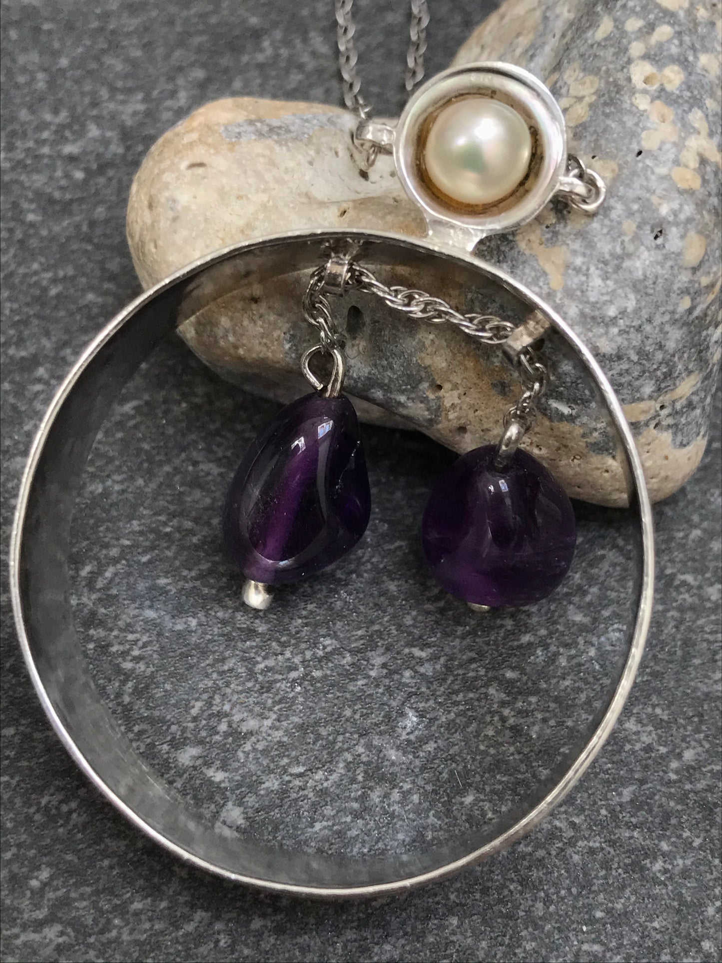 Unusual vintage circular sterling silver pendant with two amethyst drops suspended on a moving sterling silver chain.