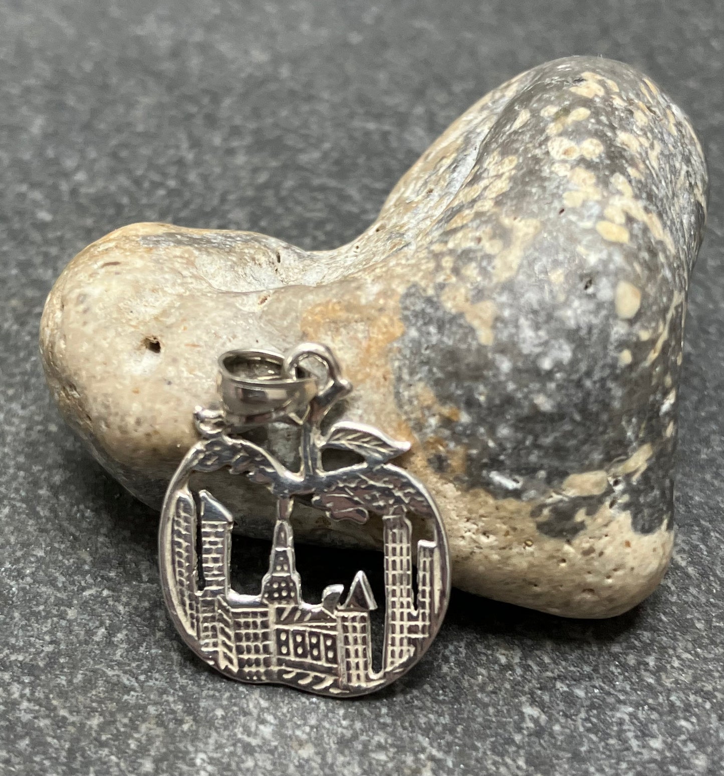 Apple pendant depicting the scene of New York sky line inside an apple.